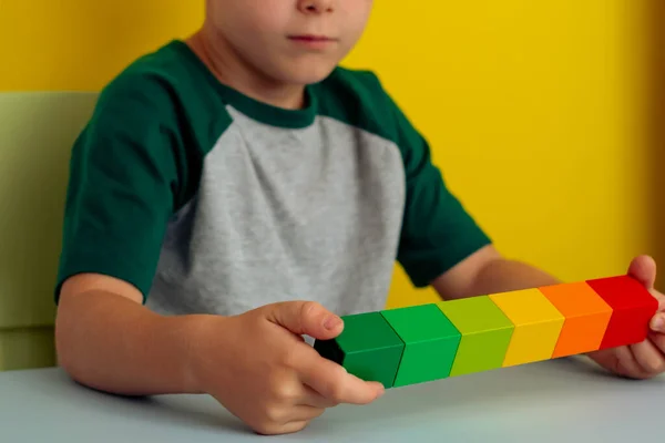 Крупним планом добрі руки, що тримають кольорові кубики в лінії — стокове фото
