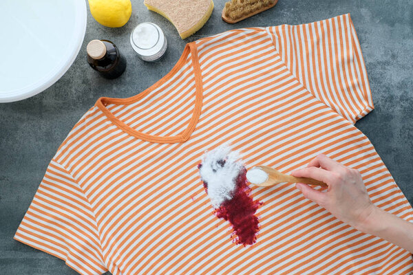  Womans hand using baking soda powder for eco-friendly stain removal. Eco-conscious and environmentally friendly choice. Sustainable living concept. top view. High quality photo