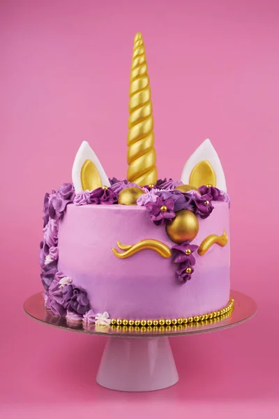 Cake unicorn with pink cream and flowers for girl\'s birthday on pink backgrounds.