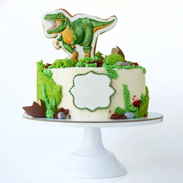 Cake with dinosaur and green leaves. Gift for the boy. Picture for a menu or a confectionery catalog.