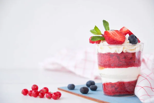 Cake dessert. Trifle red velvet in glass with fresh berries, mint leaves.