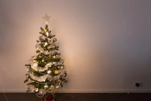 Kleine Kerstboom Staan Voor Wit Behang Ingeplugd Stralende Warme — Stockfoto