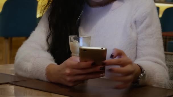 Senhora irreconhecível em um restaurante está trabalhando no telefone e beber café — Vídeo de Stock