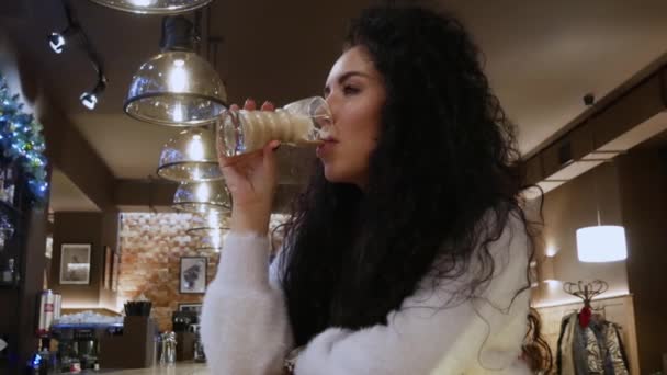 Senhora inspirada com cabelo encaracolado em um restaurante está bebendo café e sorrir — Vídeo de Stock