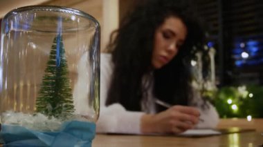 Yeni yıl ağacı cam arka plan üzerinde bir mektup yazma güzel kızla