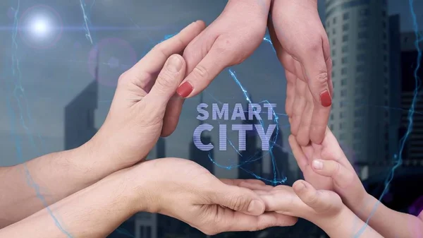 Le mani di uomini, donne e bambini mostrano un ologramma Smart city — Foto Stock