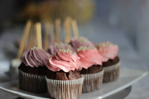 Chocolade cupcakes met roze crème op een plaat — Stockfoto