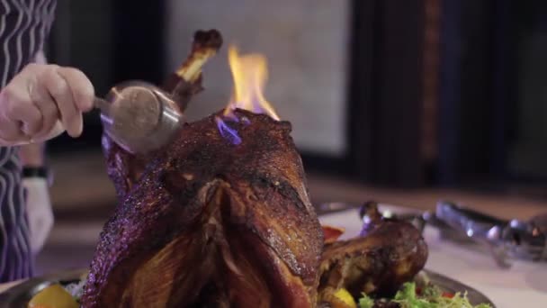 厨师在五颜六色的背景下点燃多汁的大火鸡 — 图库视频影像
