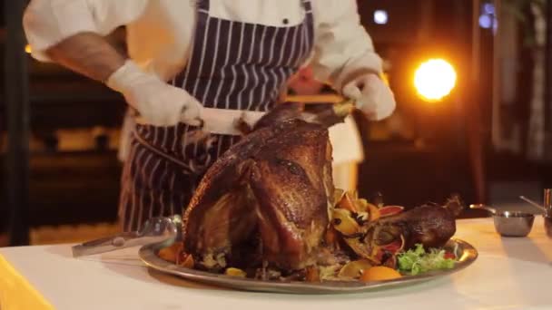 De chef-kok snijdt het sappige vlees van een grote Turkije op een kleurrijke achtergrond — Stockvideo