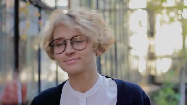 Boldog szőke nő visel szemüveget, látszó-on fényképezőgép, és levette szemüveg portréja — Stock videók