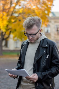 Akıllı düşünceli biri rahat kıyafetler içinde elinde kağıtları arıyor