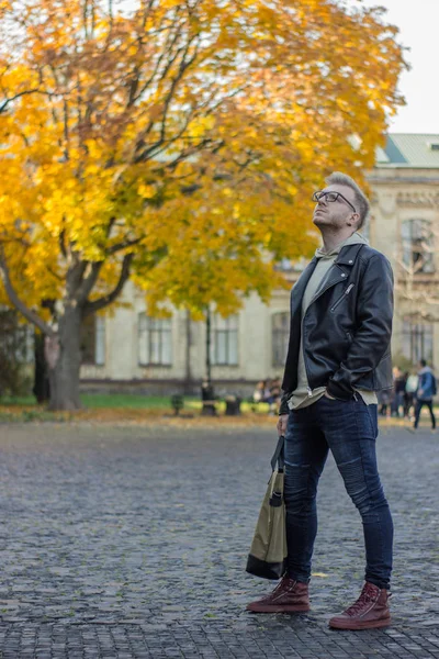 Smart lächelnder Kerl in lässiger Kleidung, der nach rechts und oben schaut — Stockfoto