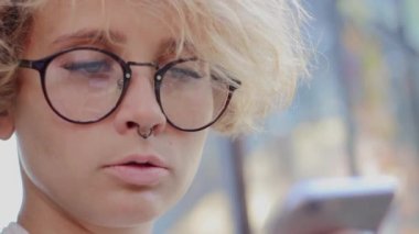 Sarışın gözlüklü telefon görünüyor