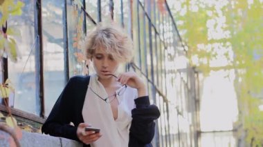 Seksi sarışın gözlüklü mutlu telefon görünüyor