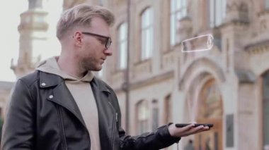 Akıllı genç adam gözlüklü gösterir kavramsal bir hologram Bitcoin içinde yatırım