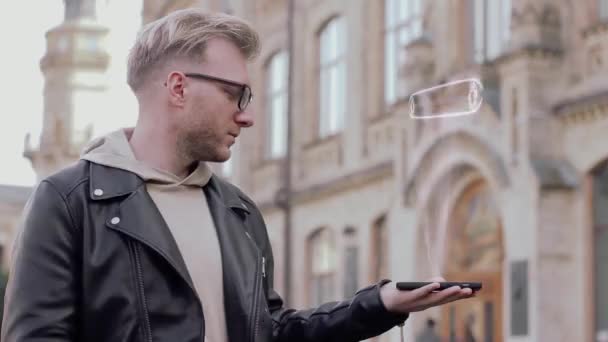 Jovem inteligente com óculos mostra um holograma conceitual Investir em Bitcoin — Vídeo de Stock