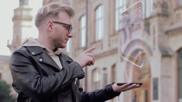 Smart young man with glasses shows a conceptual hologram mechanical clock — Stock Video