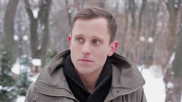 Portrait of a happy young man showing gesture OK standing in the forest in winter — Stock Video