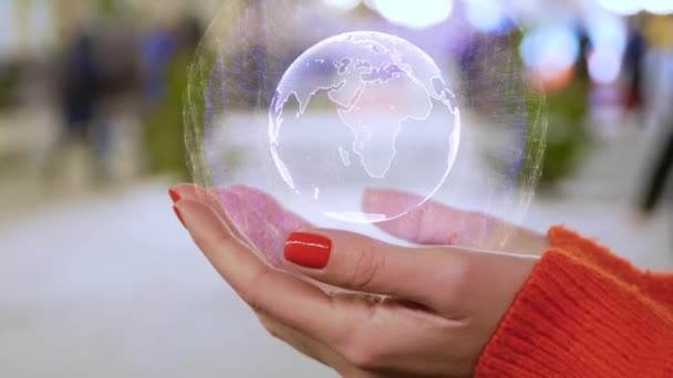 Manos femeninas sosteniendo un holograma conceptual con el planeta Tierra — Vídeo de stock