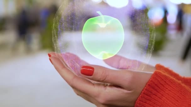 Manos femeninas sosteniendo un holograma conceptual con manzana — Vídeo de stock