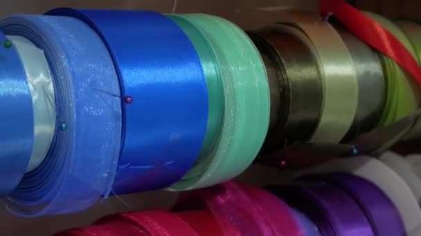 Una variedad de cintas de colores en soportes especiales en una florería — Vídeo de stock