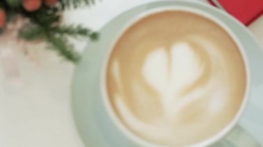Kamera ile bulanıklık sayesinde crema üzerinde bir kalp ile bir fincan kapuçino göz atın