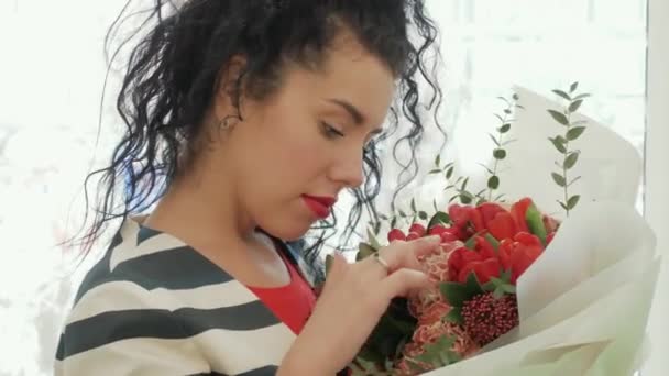 Bella donna riccia con un bellissimo bouquet vicino alla finestra — Video Stock