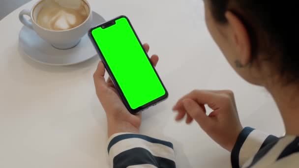 Une femme parle à un ami lors d'un appel vidéo sur un smartphone à écran vert — Video