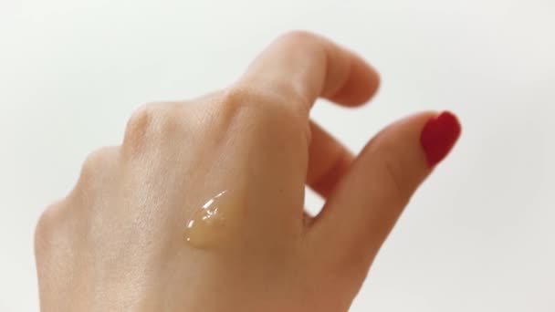 Toepassing van hand olie, huidverzorging op een witte achtergrond — Stockvideo