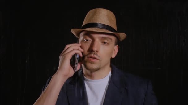Homem de chapéu e casaco fala ao telefone — Vídeo de Stock