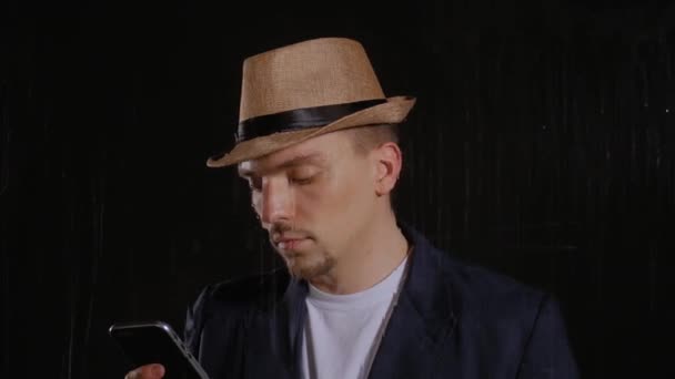 Uomo con cappello e giacca usa il telefono — Video Stock