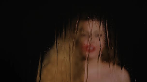 Blurred woman sings in wet window — Stock Video