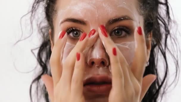 Woman applies face cream to her eyes — Stock Video
