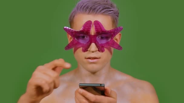 Mann benutzt Telefon auf grünem Hintergrund — Stockvideo