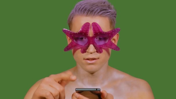 Man uses a phone on a green background — Stock Video