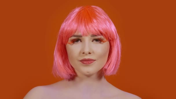 Femme avec un maquillage lumineux sur un fond orange — Video