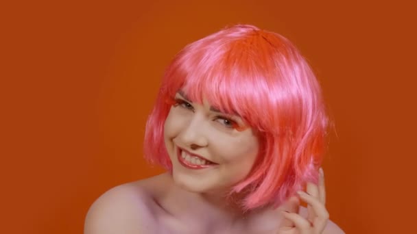 Woman blows a kiss on an orange background — Stock Video