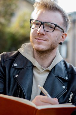 Gündelik giysiler içinde akıllı adam yaratıcısı Portresi bir not defterinotlar yapar