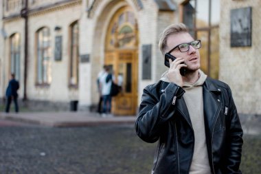 Dreaming akıllı adam üniversite kopya alanı yakınında dururken telefonda konuşuyor