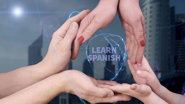 Ανδρικά, γυναικεία και παιδικά χέρια δείχνουν ένα ολόγραμμα Μάθετε Ισπανικά — Φωτογραφία Αρχείου