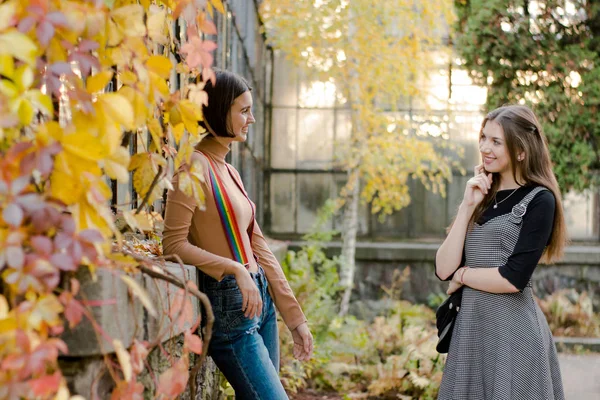 Zwei junge hübsche Studentinnen spazieren im Herbstpark — Stockfoto