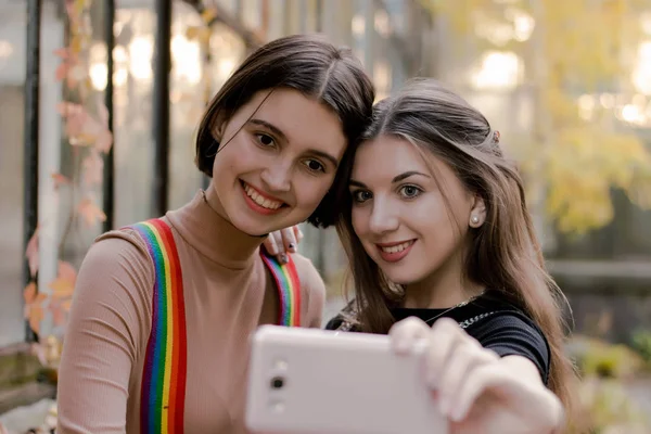 Zwei schöne Studentinnen beim Selfie am Telefon im Herbstpark — Stockfoto