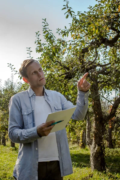 Tipul cu haine casual ţine un stilou cu hârtii. Imagini stoc fără drepturi de autor