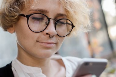 Telefona bakan gülümseyen bir kızın yakın çekim