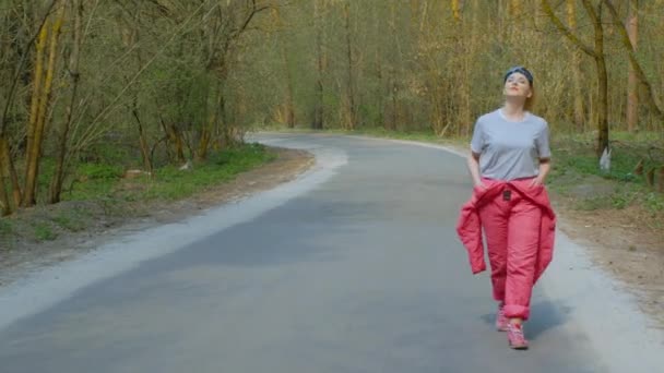 Молода жінка в лижному костюмі в лісі — стокове відео