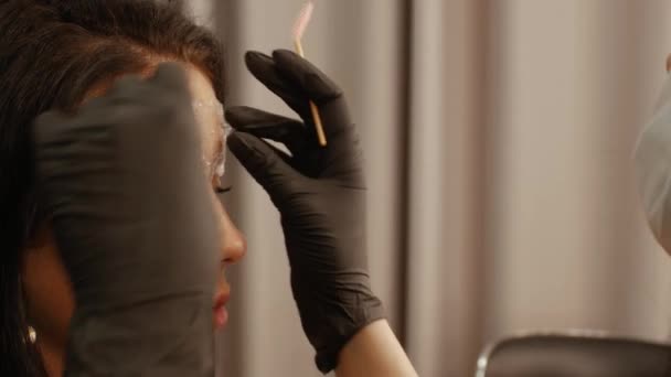 Косметолог расчесывает брови — стоковое видео