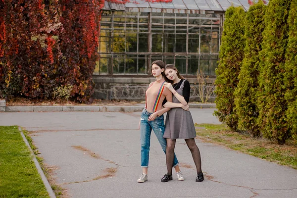 Das Mädchen umarmt seine Freundin im herbstlichen Park — Stockfoto
