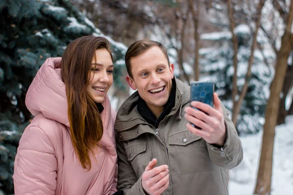 Pareja feliz tomando fotos sobre fondo de invierno Imágenes De Stock Sin Royalties Gratis