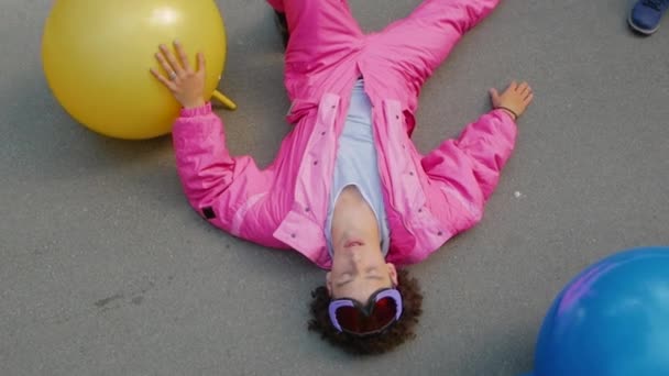 Кучерявий хлопець лежав на асфальті — стокове відео