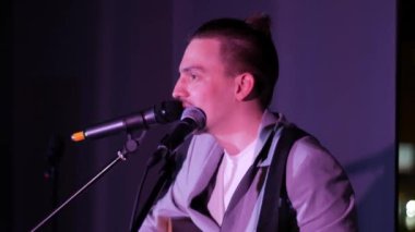Adam gitar çalıyor ve şarkı söylüyor